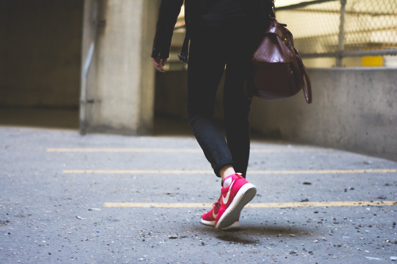 A woman in sportswear and pink Nike trainers