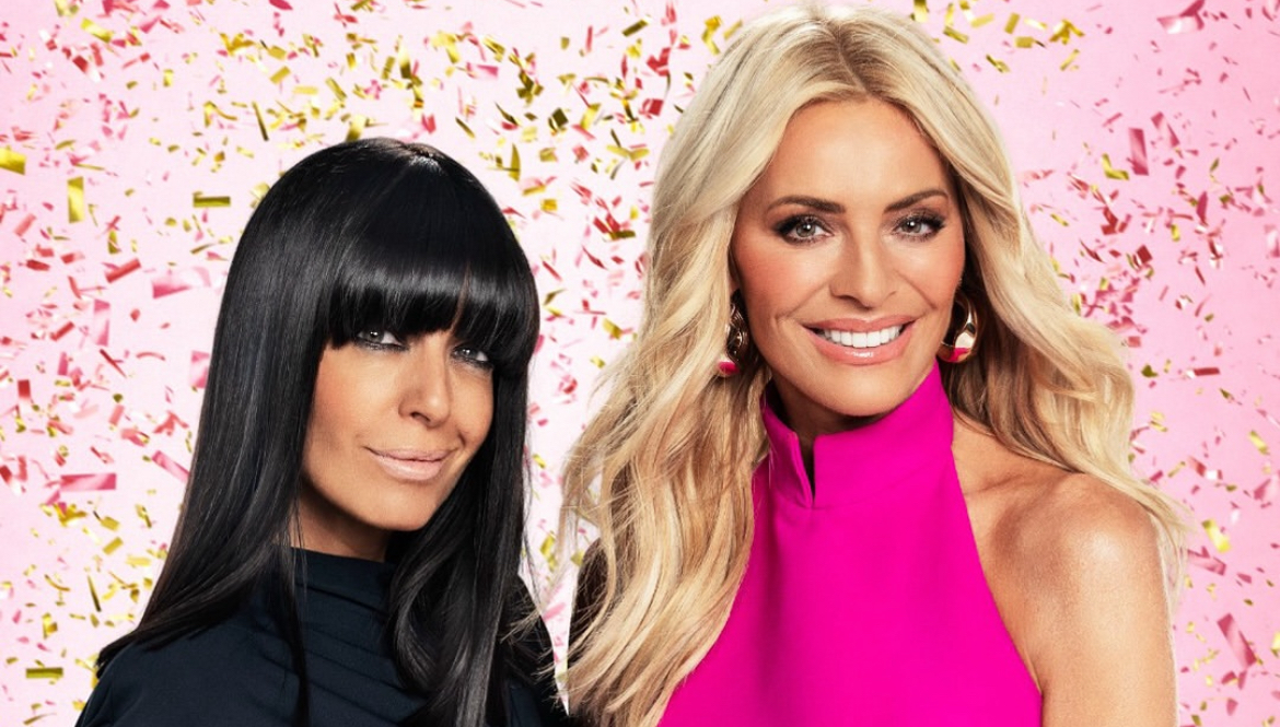 Tess Daly and Claudia Winkleman are smiling in front of a pink backdrop, there is confetti falling